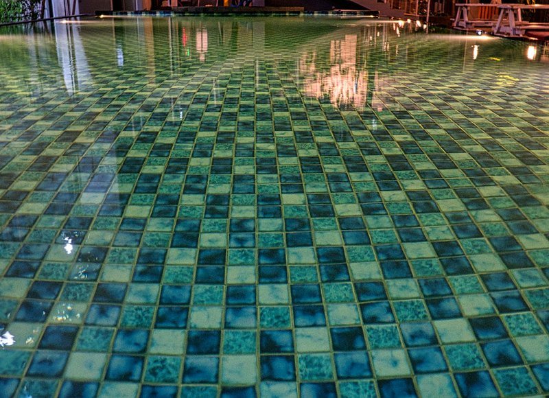 Aqua pool water shimmering over blue mosaic tile